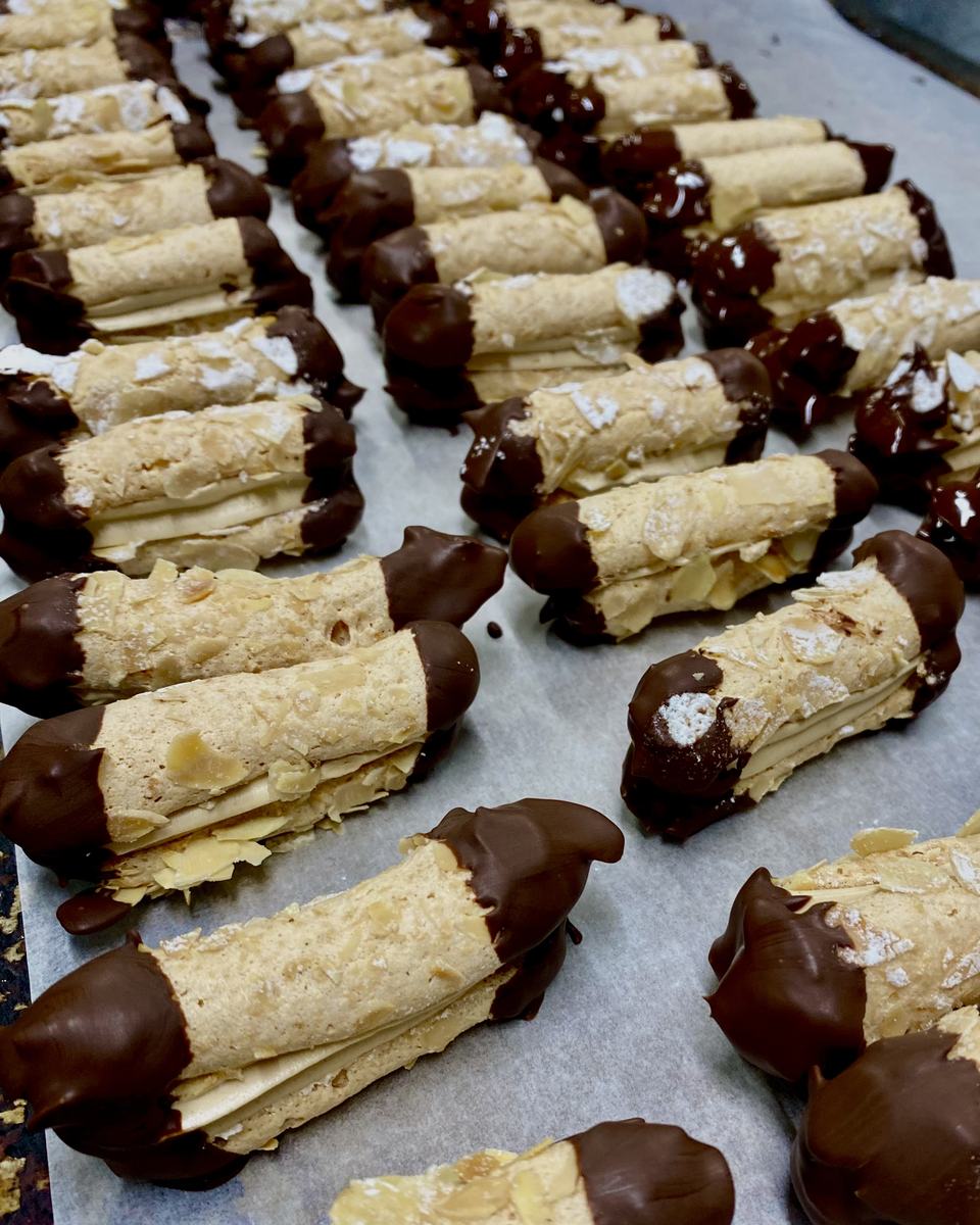 Een bakplaat vol amandelgebakjes met chocolade